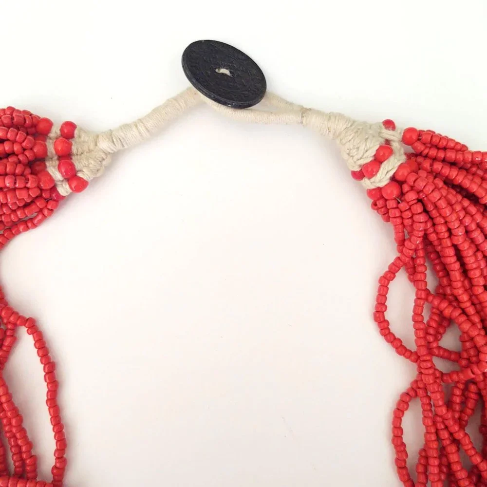 Layered orange beaded necklace with old coin toggle closure